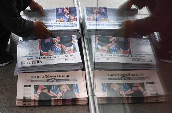 A South Korean newspaper deliveryman collects newspapers in Seoul reporting the summit between U.S. President Donald Trump and North Korean leader Kim Jong Un on June 12, (Photo/JUNG YEON-JE/AFP/Getty Images)