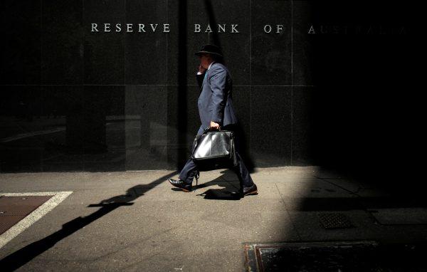 A Sydney businessman walks into the light outside the Reserve Bank of Australia on Feb. 3, 2015. (Jason Reed/Reuters)