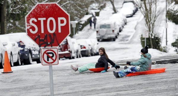 Children sled down one of Seattle's steeper hills, ice-covered Queen Anne Ave., on Feb. 4, 2019. (Photo/Elaine Thompson/AP)
