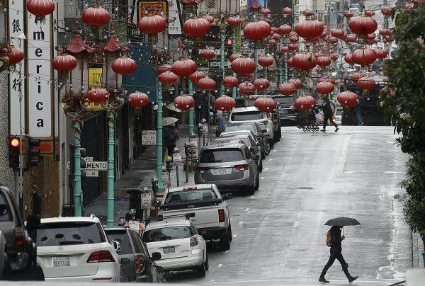 A woman walks below red lanterns hanging on Grant Avenue in San Francisco's Chinatown, on Feb. 4, 2019. (Jeff Chiu/AP)
