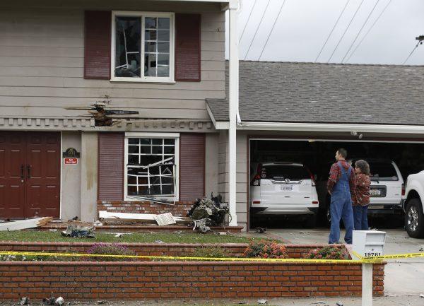 Residents look at the debris that hit their home after a small plane crashed into the residential neighborhood of Yorba Linda, Calif., on Feb. 3, 2019. (AP Photo/Alex Gallardo/AP Photo)
