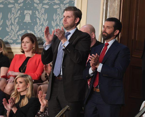 Eric Trump (L) and Donald Trump, Jr., applaud as their father President Donald Trump delivers the State of the Union address before a Joint Session of Congress on Feb. 5, 2019. (SAUL LOEB/AFP/Getty Images)