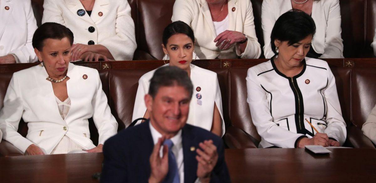 Democratic women of the House of Representatives, including Rep. Alexandria Ocasio-Cortez (D-N.Y.) (C), remain seated as Sen. Joe Manchin (D-W.Va.) stands and applauds during President Donald Trump’s State of the Union address in Washington on Feb. 5, 2019. (Jonathan Ernst/Reuters)