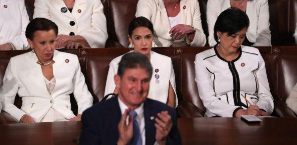 Democratic women of the House of Representatives, including Rep. Alexandria Ocasio-Cortez (D-N.Y.) (C), remain seated as Senator Joe Manchin (D-W. Va.) stands and applauds in front of them during President Donald Trump’s State of the Union address in Washington on Feb. 5, 2019. (Jonathan Ernst/Reuters)