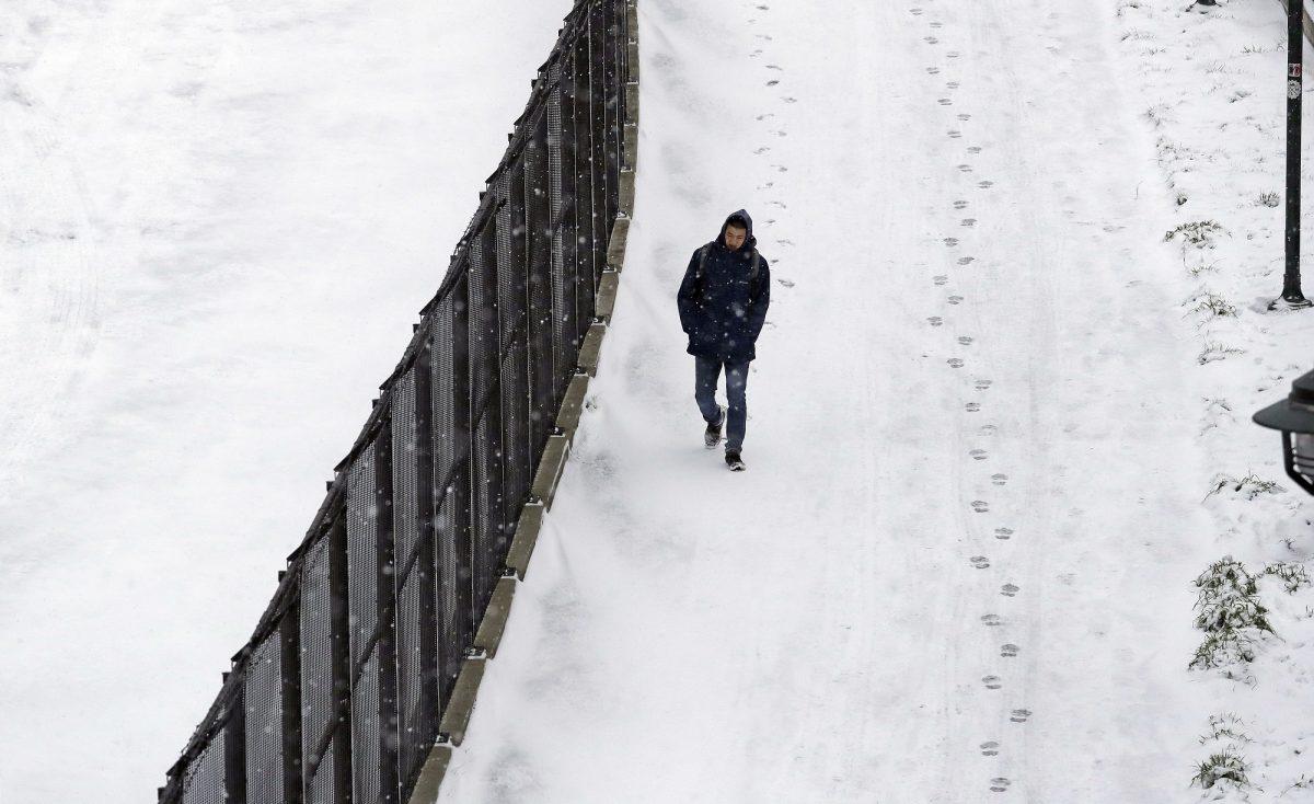 A pedestrian moves along a sidewalk in a snowstorm in Seattle on Feb. 4, 2019. (Elaine Thompson/AP Photo)