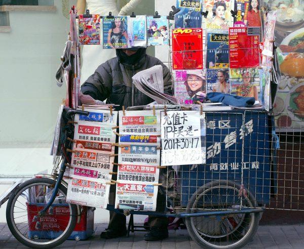 A man arranges newspaper at his newsstand in Shanghai in this file photo. (Liu Jin/AFP/Getty Images)