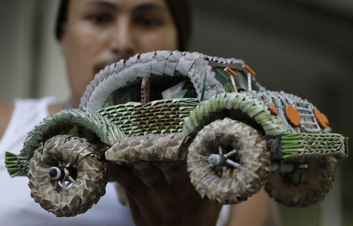 A Venezuelan migrant shows handicrafts made in with the all-but worthless Venezuelan currency on Feb. 6, 2019. (AP Photo/Fernando Vergara)