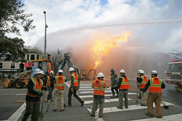 PG&E officials as firefighters battle a fire following an explosion in San Francisco, Calif., on Feb. 6, 2019. (Santiago Mejia/San Francisco Chronicle via AP)