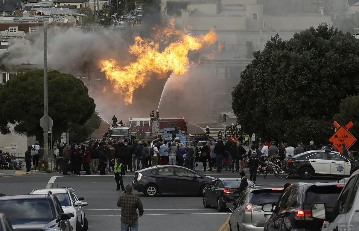 San Francisco firefighters battle a fire on Geary Boulevard in San Francisco, Wednesday, Feb. 6, 2019. A gas explosion in a San Francisco neighborhood shot flames high into the air Wednesday and was burning several buildings as utility crews scrambled to shut off the flow of gas. Construction workers cut a natural gas line, San Francisco Fire Chief Joanne Hayes-White said. (AP Photo/Jeff Chiu)
