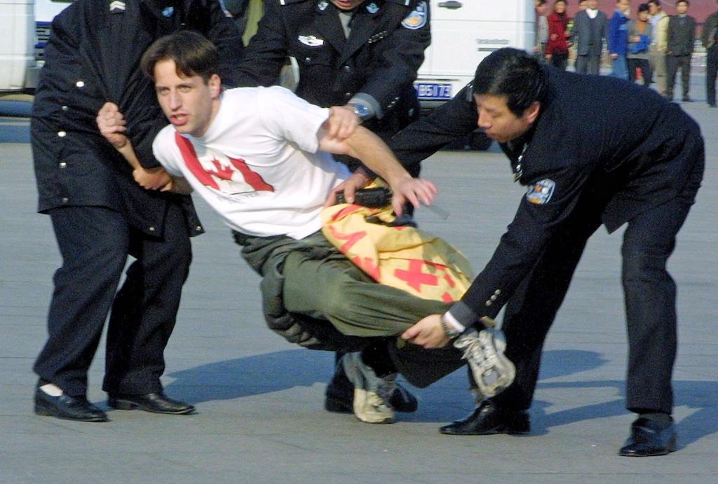 Zenon Dolnyckyj is wrestled down by Chinese police officers in Tiananmen Square after participating in a sit-in demonstration in support of Falun Gong on Nov. 20, 2001. About twenty Westerners took part in the sit-in and unfurled a giant banner before being taken away and detained by police. (AP Photo/Ng Han Guan)
