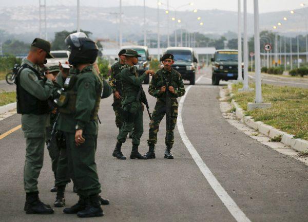 Venezuelan soldiers block the main access to the Tienditas International Bridge that links Colombia and Venezuela, near Urena, Venezuela, Feb. 7, 2019. (AP Photo/Fernando Llano)