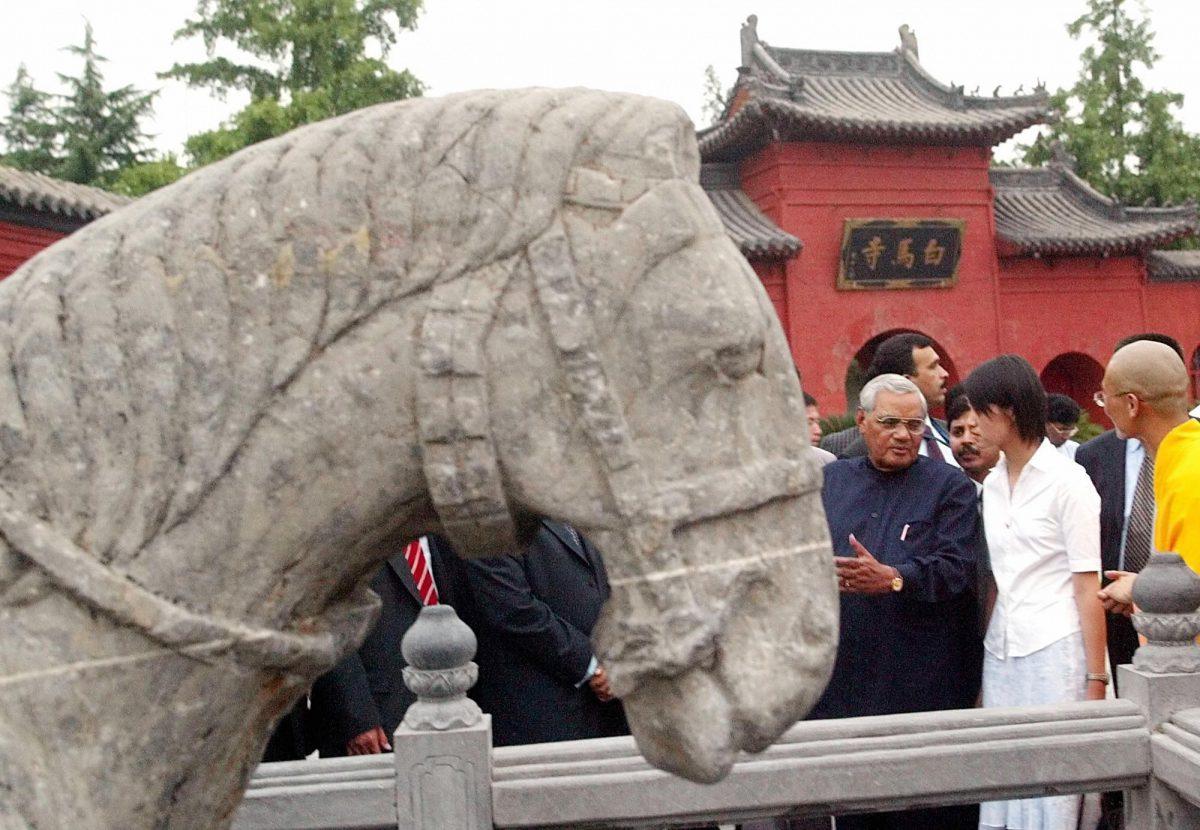 India's prime minister Atal Bihari Vajpayee (L) asks a question about a stone sculpture of a horse near the entrance to the “Baima” or White Horse temple in Luoyang, Henan, Central China, June 25, 2003. Vajpayee's visit to Luoyang is significant as it is the place where two Indian monks first introduced Buddhism to China. (Ng Han Guan/AFP/Getty Images)