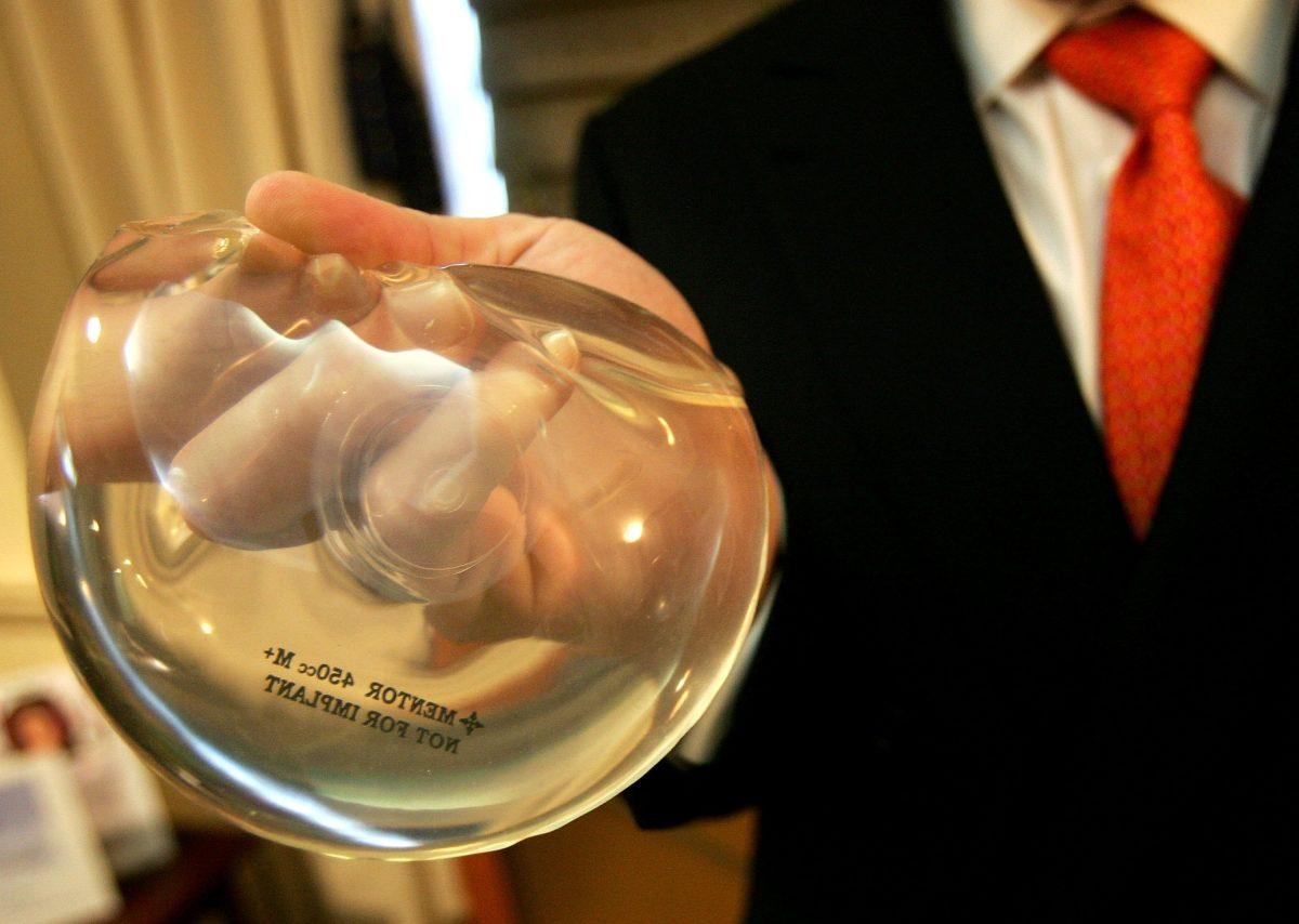 Dr. Brad Jacobs holds up a silicone implant gel (L) and a saline implant gel (R) inside of his office in New York City, on Nov. 21, 2006. (Spencer Platt/Getty Images)