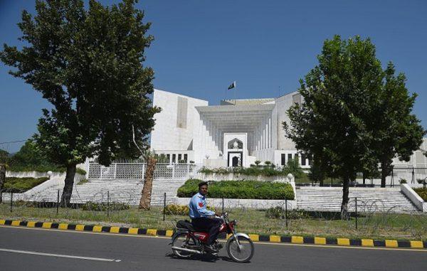 A Pakistani policemen rides past the Supreme Court building in Islamabad on Sept. 15, 2017. (Farooq Naeem/AFP/Getty Images)