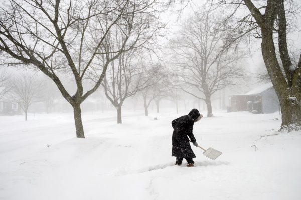 Abby Morin shovels a path as snow continues to fall in Grand Rapids, Mich., on Feb. 8, 2019. (Neil Blake/The Grand Rapids Press via AP)