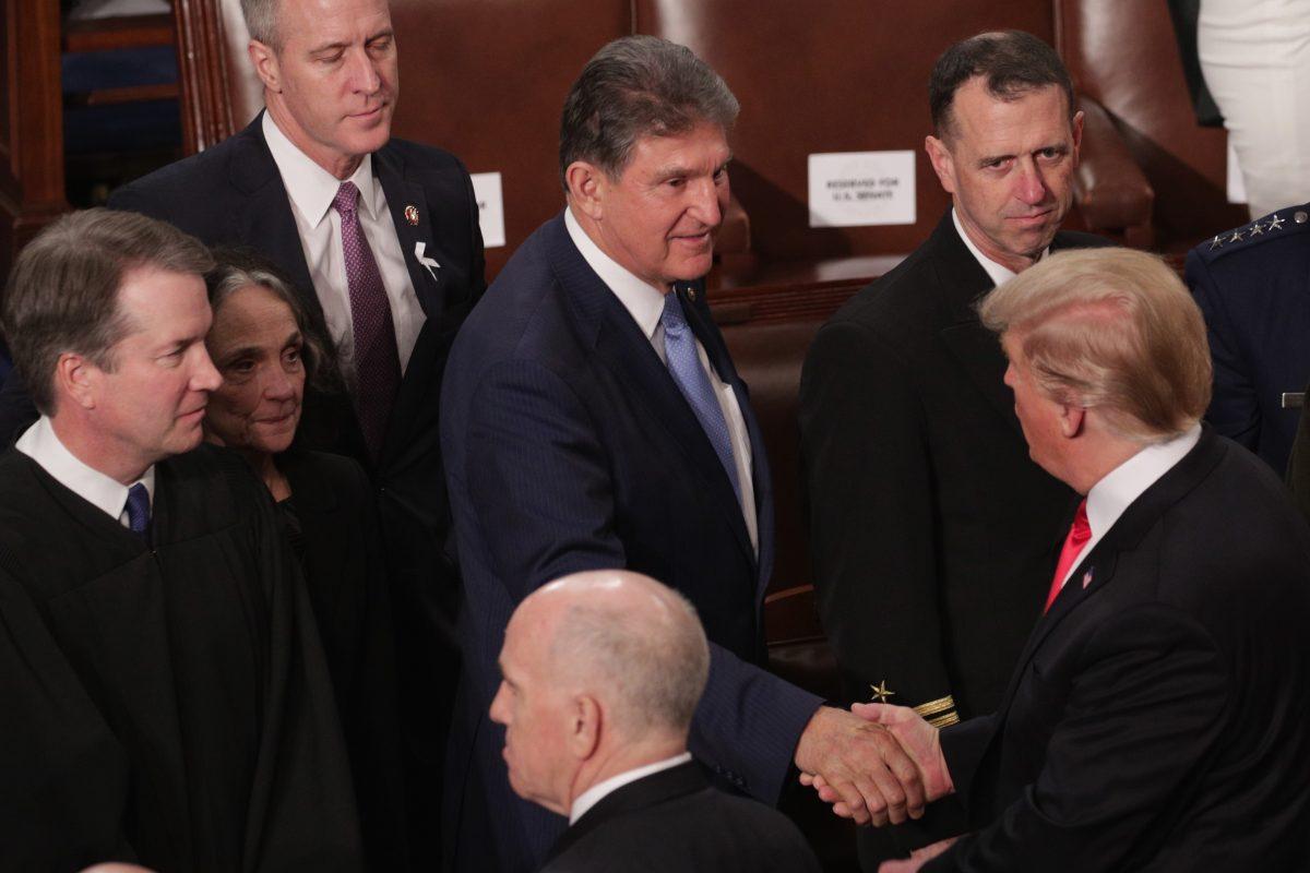 Sen. Joe Manchin (D-W. Va.) shakes the hand of President Donald Trump in the chamber of the House of Representatives after Trump gave his State of the Union speech on Feb. 5, 2019. (Alex Wong/Getty Images)