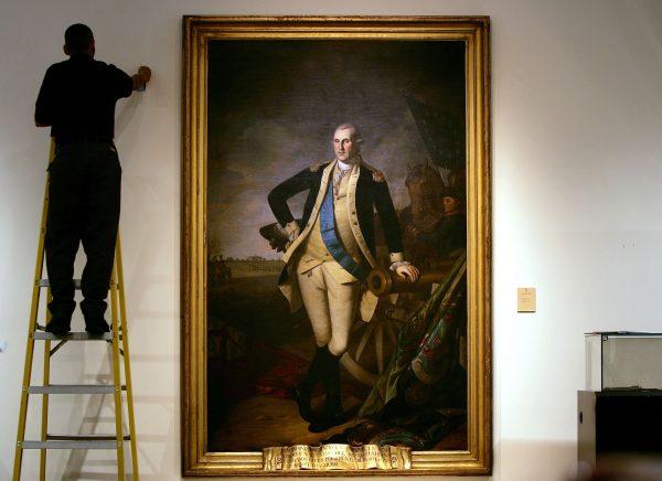 A worker uses a ladder to work near a full-length portrait of former President George Washington, by Charles Wilson Peale, at Christie's auction house in New York City, on Jan. 17, 2006. (Spencer Platt/Getty Images)