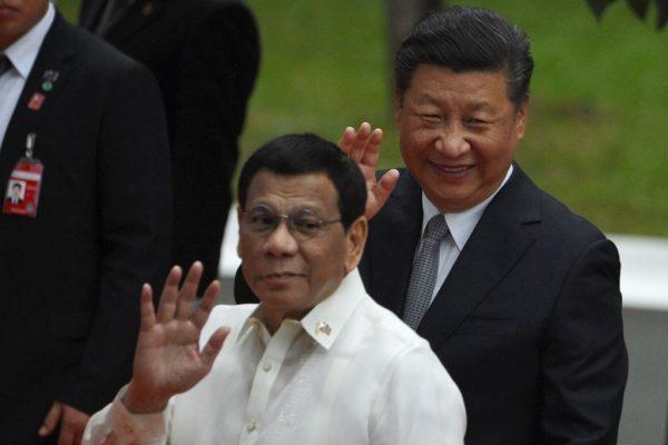 Chinese leader Xi Jinping (right) and Philippine President Rodrigo Duterte wave to members of the media, after inspecting the honor guard during a welcoming ceremony at the Malacanang Palace in Manila on Nov. 20, 2018. (Ted Aljibe/AFP/Getty Images)