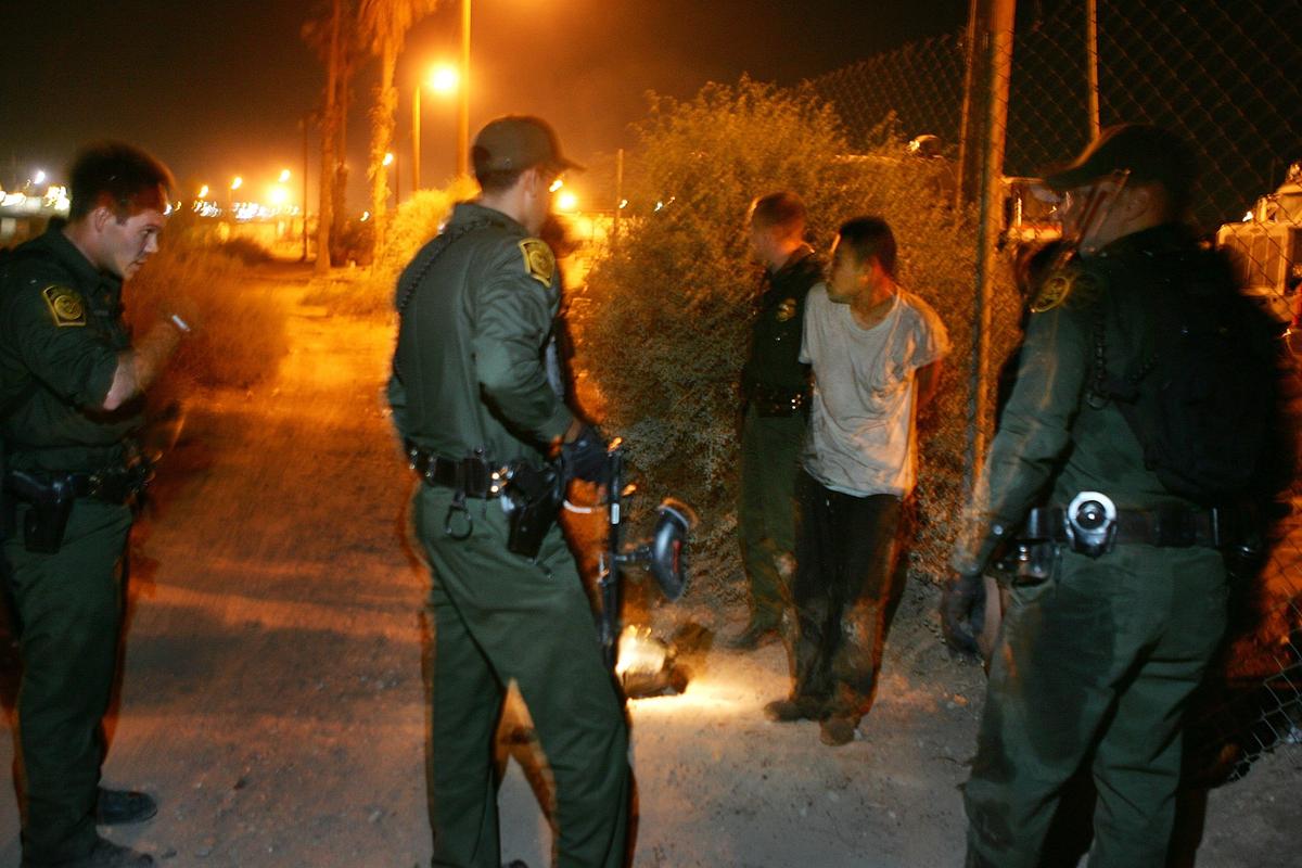 Border patrol agents arrest a man trying to illegally enter the U.S. by floating down the New River, considered the nation?s most polluted waterway, in the early morning hours on Jun. 15, 2006 in Calexico, Calif. (David McNew/Getty Images)