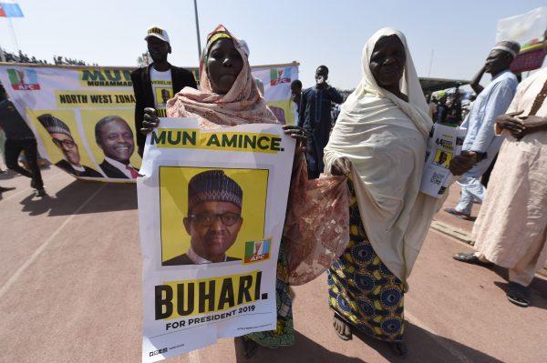 A supporter carries a banner depicting the candidate of the ruling All Progressives Congress (APC), Nigerian President Mohammadu Buhari, during a campaign rally at the Sanni Abacha Stadium in Kano, on Jan. 31, 2019. (Pius Utomi Ekpei/AFP/Getty Images)