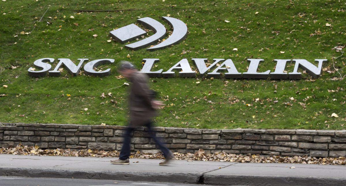 A man walks past the SNC-Lavalin Group Inc., headquarters. (Paul Chiasson/The Canadian Press)