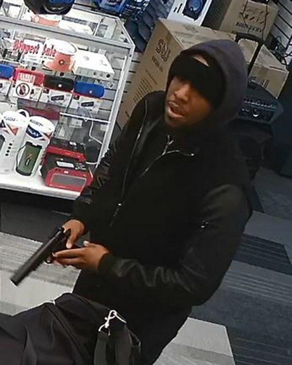 In this image taken from surveillance video provided by the New York Police Department, a man, identified by police as Christopher Ransom, is shown robbing a cell phone store in the Queens borough of New York, on Jan. 19, 2019. (NYPD via AP)