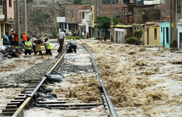 Men place sandbags along a section of the central railroad track that follows the Rimac River, which suffered severe damage by rising water and flash foods in the town of Chosica, at the foot of the Andes mountains east of Lima, on March 18, 2017. (Cris Bouroncle/AFP/Getty Images)
