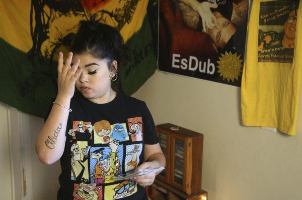 Seanna Leilani Chavez, the sister of Aaron Francisco Chavez, pauses as she looks at family photos as she stands next to a shrine for Aaron, including images of Aaron on the wall, at the family home in Tucson, Ariz., on Feb. 6, 2019. (Ross D. Franklin/AP)