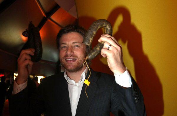 British chef Jamie Oliver holds two sausages prior to the opening of his new dinner show "Das Jamie Oliver Dinner Frankfurt" in Frankfurt, Germany, on Jan. 14, 2009. (Ralph Orlowski/Getty Images)
