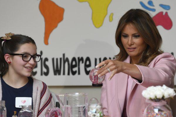 First Lady Melania Trump, right, looks at her handmade snow globe as she sits next to Abigail, left, during a visit to the National Institutes of Health to see children at the Children's Inn to celebrate Valentine's Day, in Bethesda, Md., on Feb. 14, 2019. (Susan Walsh/AP)