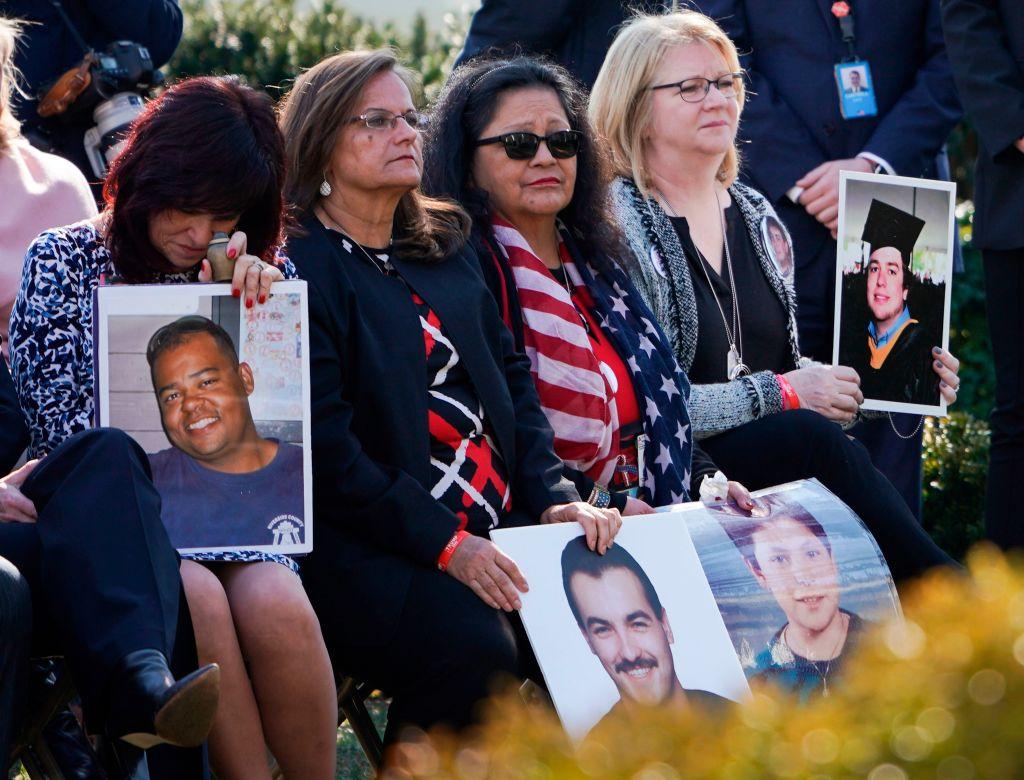 Family members hold portraits of loved one that were victims of crimes committed by undocumented immigrants, as President Donald Trump delivers remarks, in the Rose Garden at the White House in Washington on February 15, 2019. (Brendan Smialowski/AFP/Getty Images)
