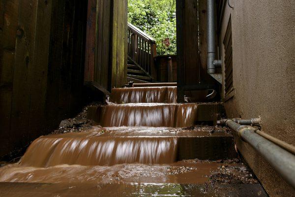 Water rushes down the stairs of a house near a mudslide that destroyed three homes on a hillside in Sausalito, Calif., on Feb. 14, 2019. (AP Photo/Michael Short)