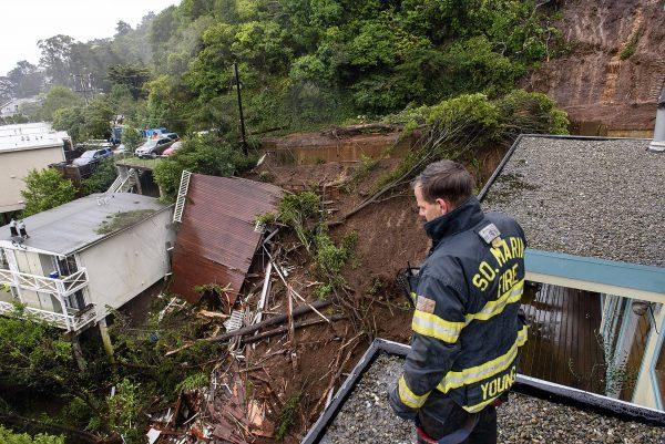 Firefighter/paramedic Patrick Young with the Southern Marin Fire Department looks out over the aftermath of a mudslide that destroyed three homes on a hillside in Sausalito, Calif., on Feb. 14, 2019. (AP Photo/Michael Short)