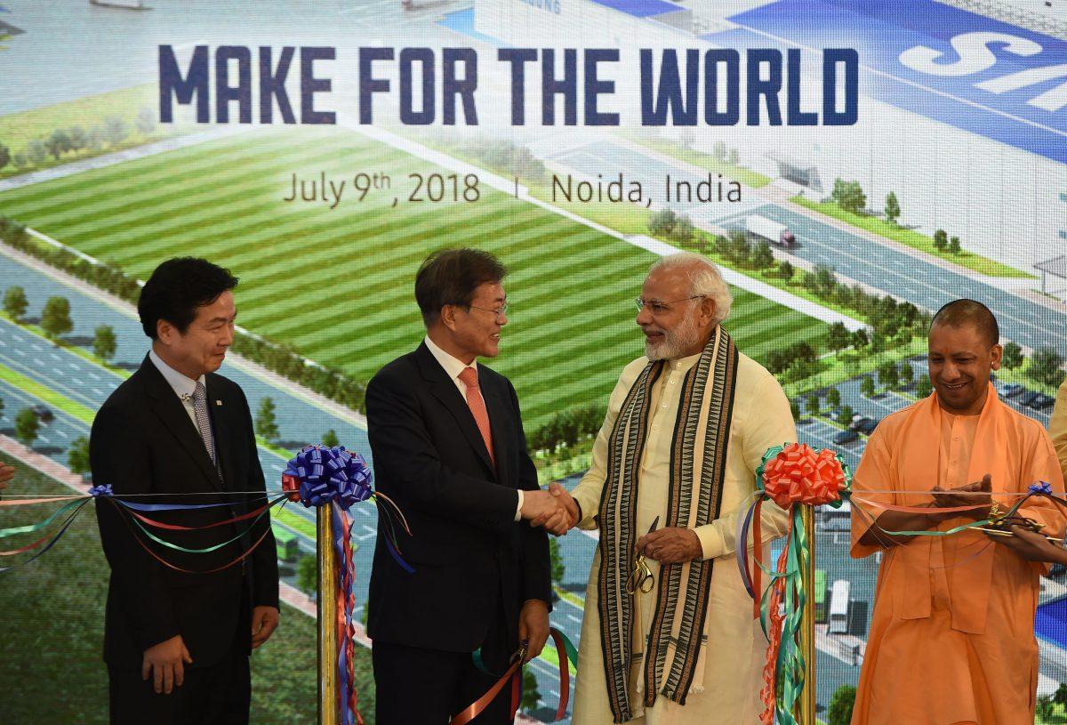 South Korea's President Moon Jae-in (center left) shakes hands with India's Prime Minister Narendra Modi (center right) as Chief Minister of Uttar Pradesh state Yogi Adityanath (R) looks on during the inauguration of the world's largest smartphone factory in Noida, India on July 9, 2018. (Money Sharma/AFP/Getty Images)