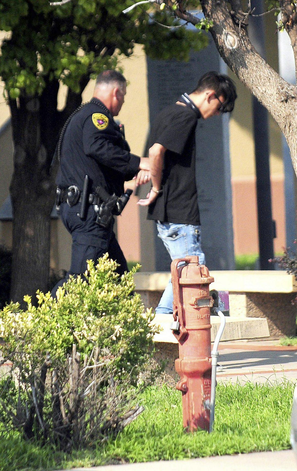 Police take Nathaniel Jouett into custody after a shooting at a public library in the eastern New Mexico community of Clovis. (Tony Bullocks/The Eastern New Mexico News via AP, File)