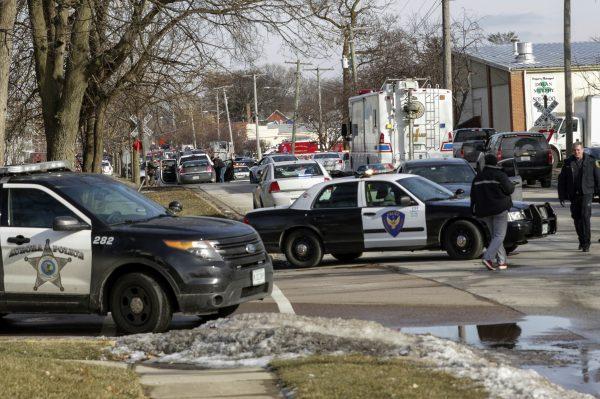Law enforcement personnel gather near the scene of a shooting at an industrial park in Aurora, Ill., on Feb. 15, 2019. (Bev Horne/Daily Herald via AP)