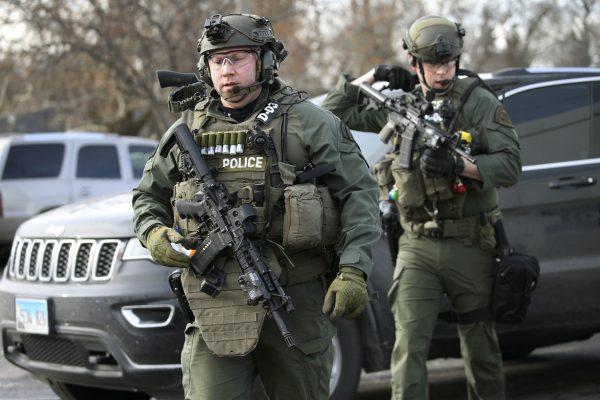 Police officers armed with rifles gather at the scene where an active shooter was reported in Aurora, Ill., on Feb. 15, 2019. (Antonio Perez/Chicago Tribune via AP)