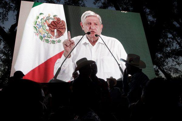 People watch Mexico's President Andres Manuel Lopez Obrador on a video screen during an event in Badiraguato, in the Mexican state of Sinaloa, Mexico on Feb. 15, 2019. (Daniel Becerril/Reuters)