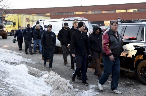 Employees are escorted from the scene of a shooting at a manufacturing plant in Aurora, Ill., that police said left several people dead and several police officers wounded, on Feb. 15, 2019. (Matt Marton/AP Photo)