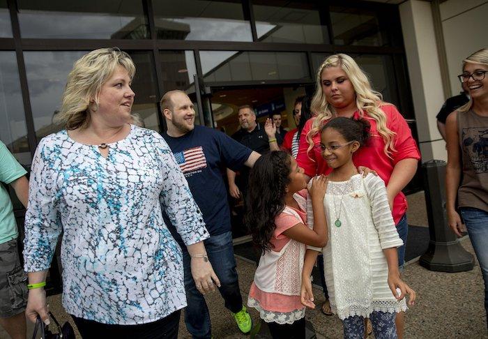 Laurie Holt (L), walks out of the airport with her son, Josh Holt, walking behind her, after returning to Salt Lake City after Josh and his family received medical care and visited President Donald Trump in Washington. On May 28, 2018. (AP Photo/Kim Raff, File)