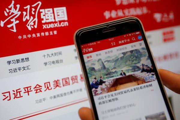 Chinese government propaganda app Xuexi Qiangguo, which literally translates as "Study to make China strong," is seen on a mobile phone in front of its website on a computer screen in this illustration picture taken on Feb. 18, 2019. (Tingshu Wang/Reuters)