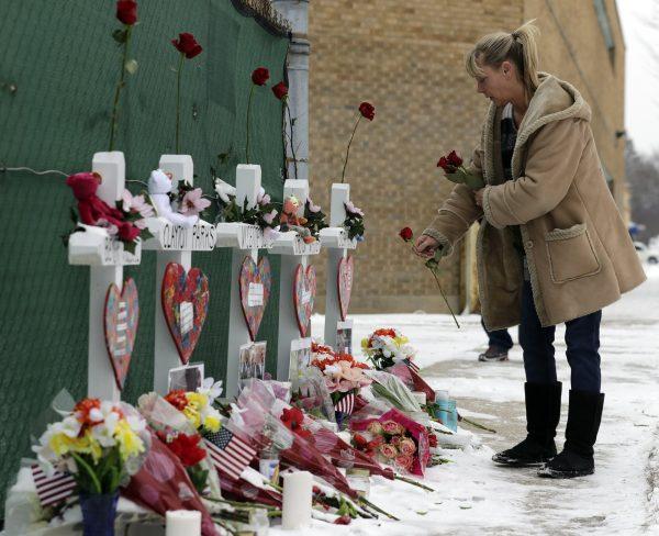 A woman places flowers at a makeshift memorial in Aurora, Ill., on Feb. 17, 2019. (Nam Y. Huh/AP)