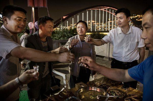 Chinese men toast each other while drinking their locally made wine called baijiu at dinneri in China. (Kevin Frayer/Getty Images)