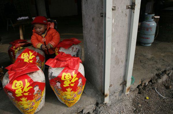 A child looks at wine jars before a feast. (China Photos/Getty Images)