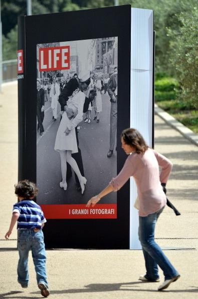 A People pass by a poster announcing the "Life. I grandi fotografi" (Life. The great photographers) exhibition with "VJ Day a Times Square, New York, NY, 1945" by Alfred Eisenstaedt at the auditorium in Rome on April 30, 2013. (Gabriel Bouys/AFP/Getty Images)