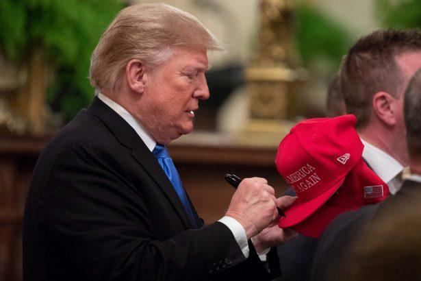 President Donald Trump signs MAGA hats after addressing the Young Black Leadership Summit at the White House, on Oct. 26, 2018. (Alex Edelman/AFP/Getty Images)