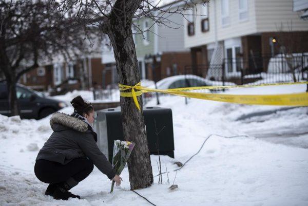 Local resident Jennifer Fuller places flowers at the scene outside of a house where a young girl was found dead in Brampton, Ont., Canada, on Feb. 15, 2019. (Andrew Ryan/he Canadian Press)