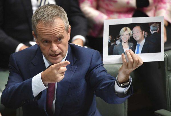 Australian Opposition Leader Bill Shorten holds a photograph of Australian Foreign Minister Julie Bishop with Chinese businessman Huang Xiangmo during House of Representatives Question Time at Parliament House in Canberra, June 14, 2017. (AAP Image/Lukas Coch)