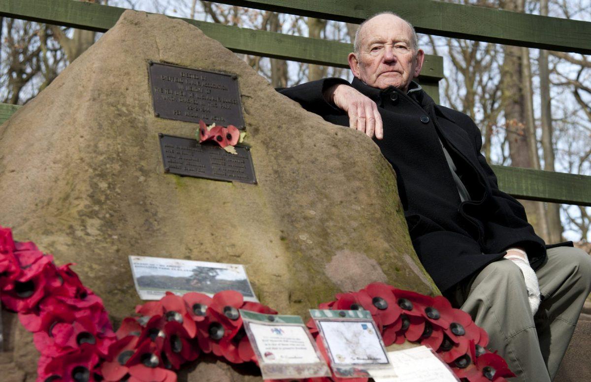 Tony Foulds sits next to a memorial honoring 10 U.S. airmen who died in a plane crash in Endcliffe Park, Sheffield, England, on Feb. 13, 2019. (Rui Vieira/AP Photo)