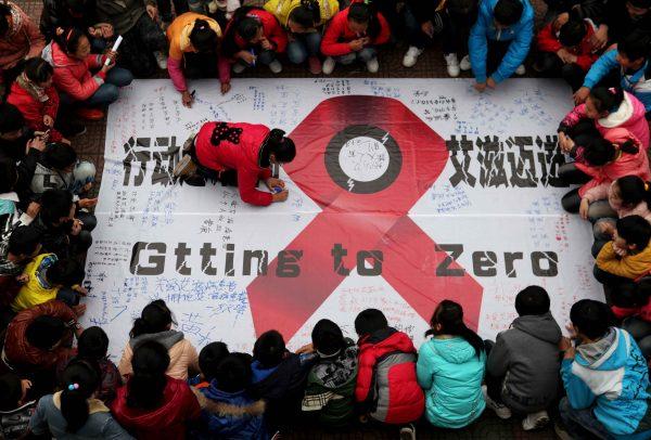 Students sign their names on an anti-AIDS banner during a AIDS day event at a school in Hanshan, central China's Anhui Province on Nov. 30, one day before the 2012 AIDS day. Chinese AIDS activists on Nov. 29 accused the Communist Party's Li Keqiang of hypocrisy after he called for more non-government efforts to fight the disease. (STR/AFP/Getty Images)